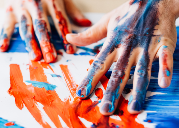 a person's hands are painted with red, blue, and white paint