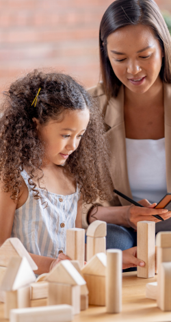 A therapist paying with a children with wooden blocks