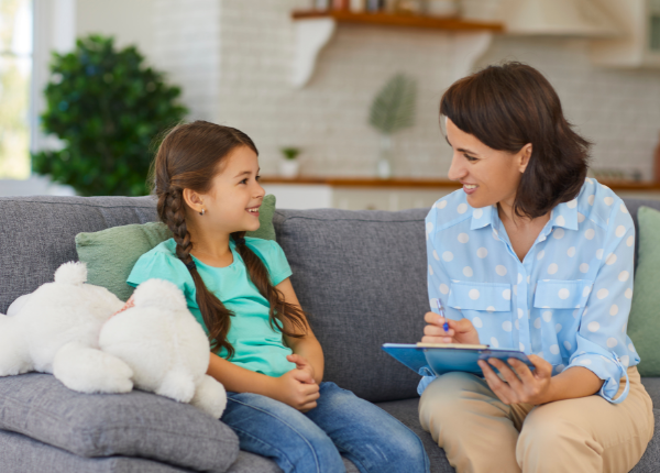 A person is talking to a child on a couch